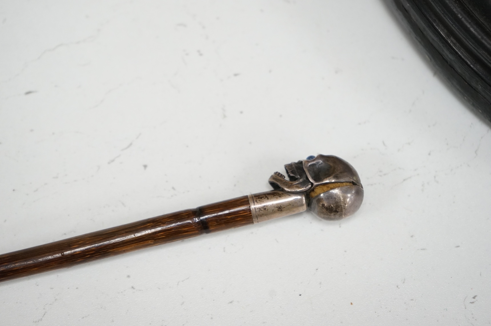 A 19th century bamboo walking stick with memento mori skull finial, the skull with articulated jaw, 84cm in length